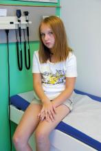 A girl waits to be seen by a doctor